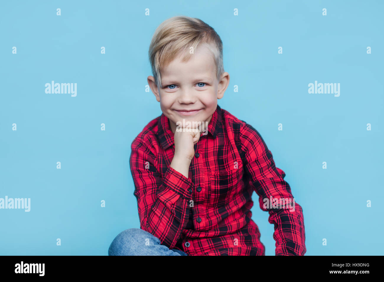 Modische kleines Kind mit roten Hemd. Mode. Stil. Studio-Porträt über blauem Hintergrund Stockfoto