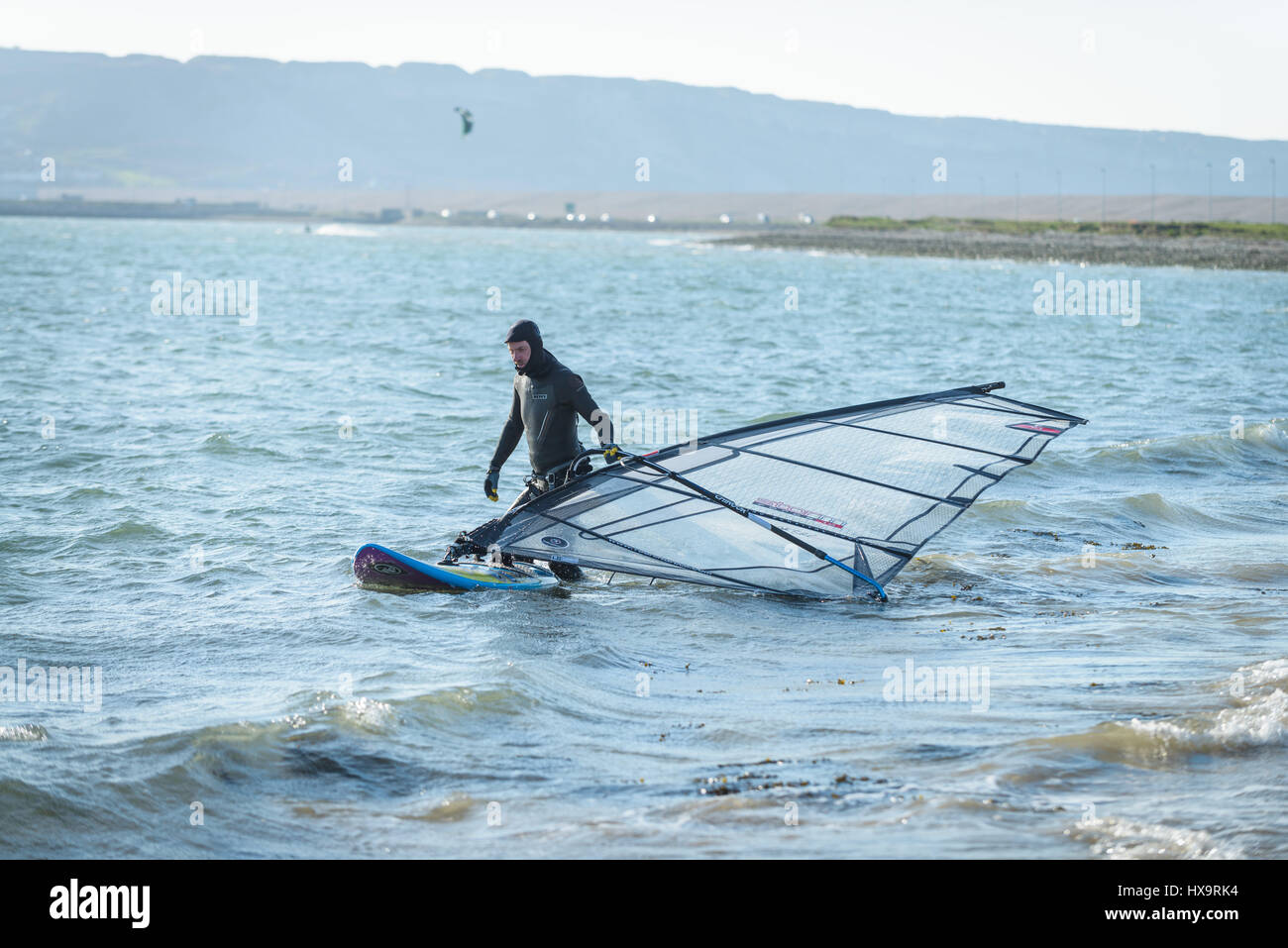 Hafen von Portland, Dorset, UK. 26. März 2017. Ein Mann Vorbereitung sein Windsurfen Board an einem knackigen windigen sonnigen Tag im Hafen von Portland auf Mothering Sunday.  © Dan Tucker/Alamy Live-Nachrichten Stockfoto