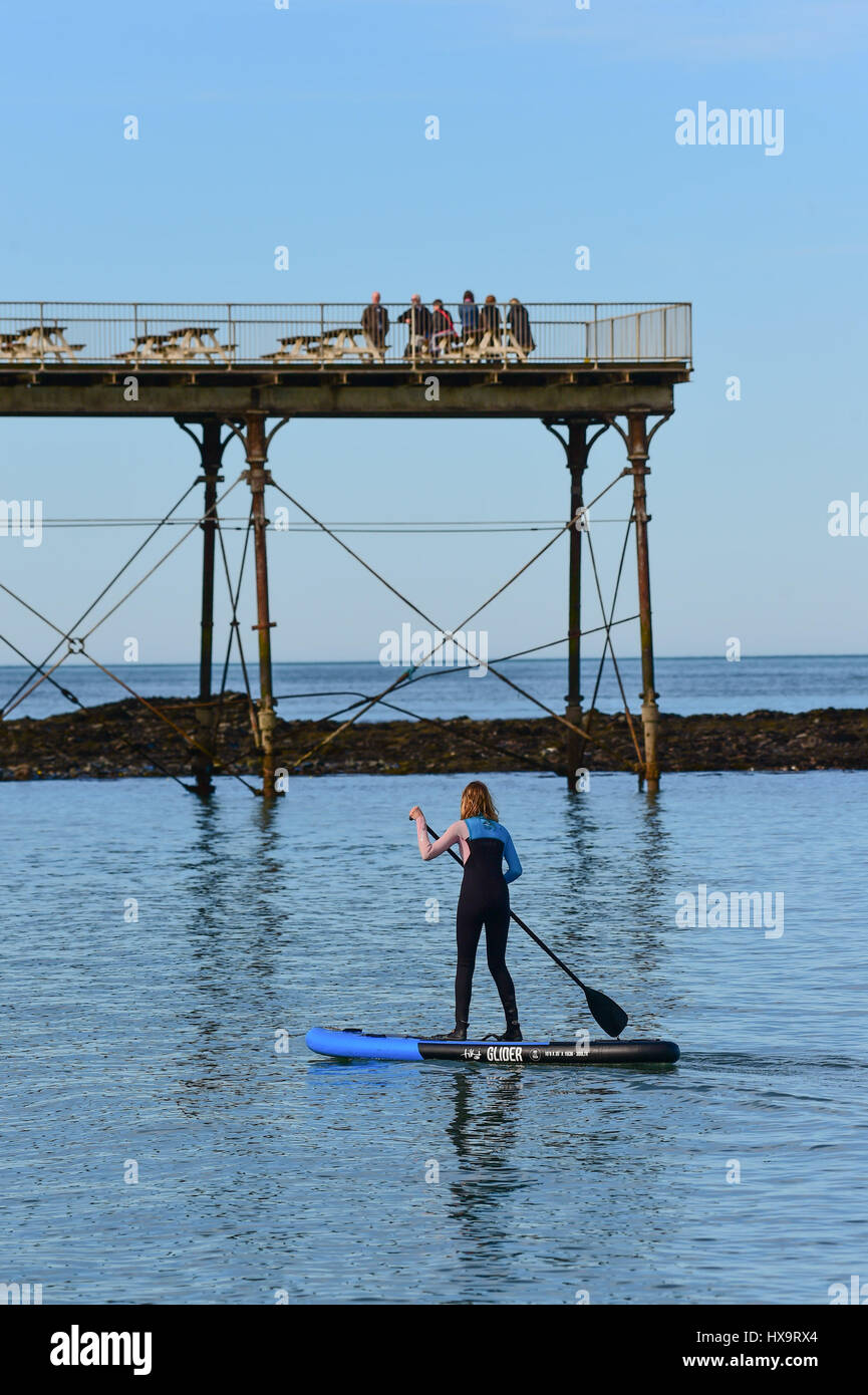 Aberystwyth, Wales UK, Muttertag, Sonntag, 26. März 2017 UK Wetter: eine junge Frau in einen Neoprenanzug Paddel auf ihre SUB (Stand-up Board) auf das flache Meer. Es ist ein anderer Tag von strahlendem Sonnenschein und blauem Himmel in Aberystwyth an der Westküste von Wales klar. Bildnachweis: Keith Morris/Alamy Live-Nachrichten Stockfoto