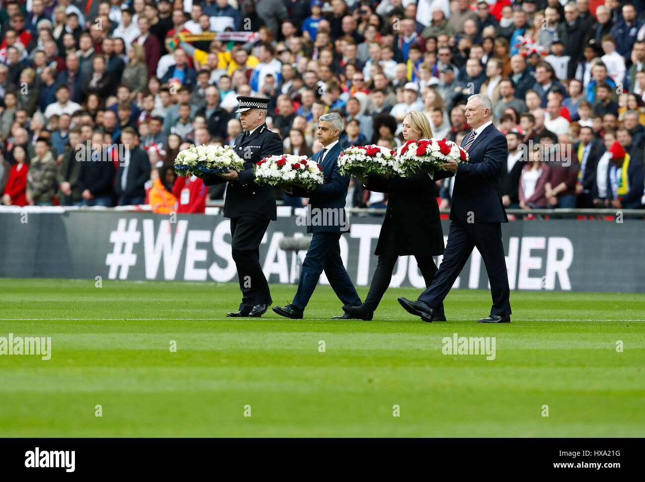 London, UK. 26. März 2017. Bürgermeister von London Sadiq Khan (2. L) tragen Blüten zu Ehren der Opfer des Westminster-Terror-Anschlag vor der FIFA World Cup europäische Qualifikation Gruppe F Spiel zwischen England und Litauen im Wembley Stadion in London, Großbritannien am 26. März 2017. England gewann mit 2: 0. Bildnachweis: Han Yan/Xinhua/Alamy Live-Nachrichten Stockfoto