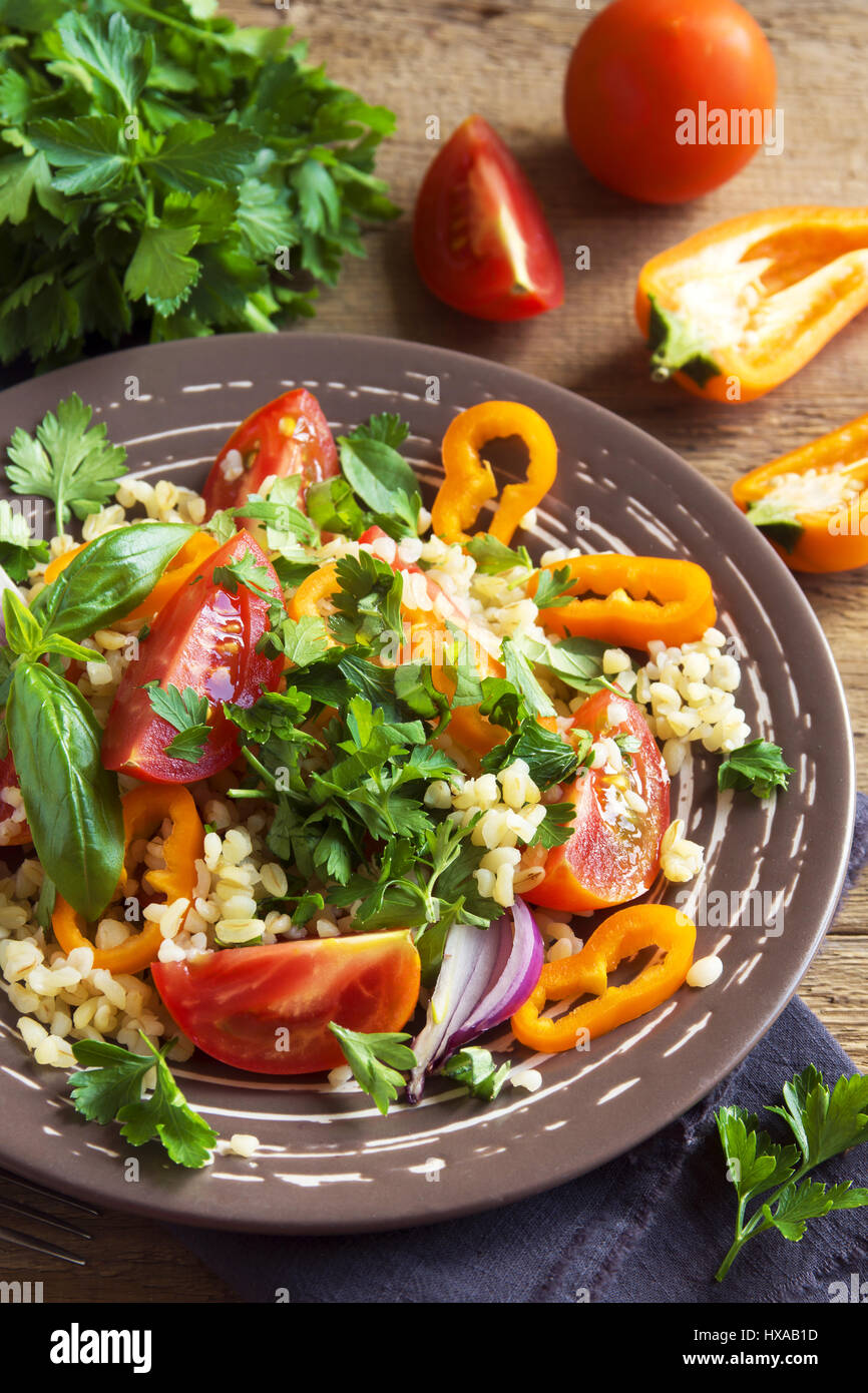 Tomaten-Couscous-Salat mit Gemüse und grünen - gesunde vegetarische vegane Gemüse Bio Diät Salat essen über rustikalen Holztisch mit Kopie s Stockfoto