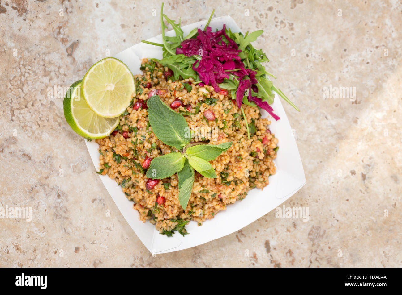 Orientalische Speisen - vegetarisches Essen bestehend aus Bulgur-Weizen-Salat, Raketen, Sauerkraut Limetten und Minze - Konzept - gesunde Ernährung Stockfoto