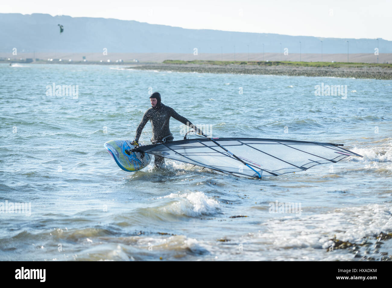 Hafen von Portland, Dorset, UK. 26. März 2017. Ein Mann Vorbereitung sein Windsurfen Board an einem knackigen windigen sonnigen Tag im Hafen von Portland auf Mothering Sunday.  © Dan Tucker/Alamy Live-Nachrichten Stockfoto