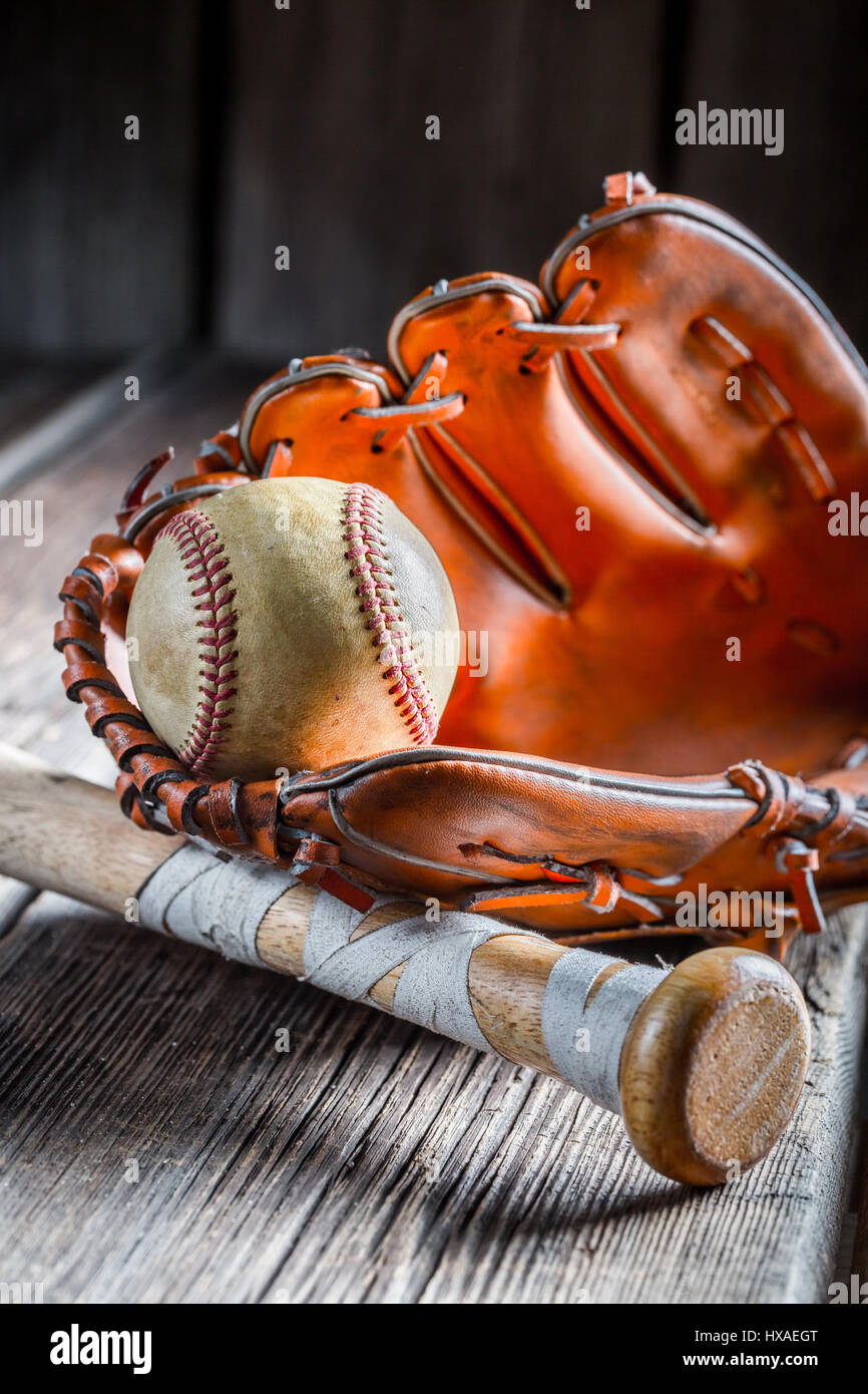 Alten Baseball Ball und goldener Handschuh auf alten Holztisch Stockfoto
