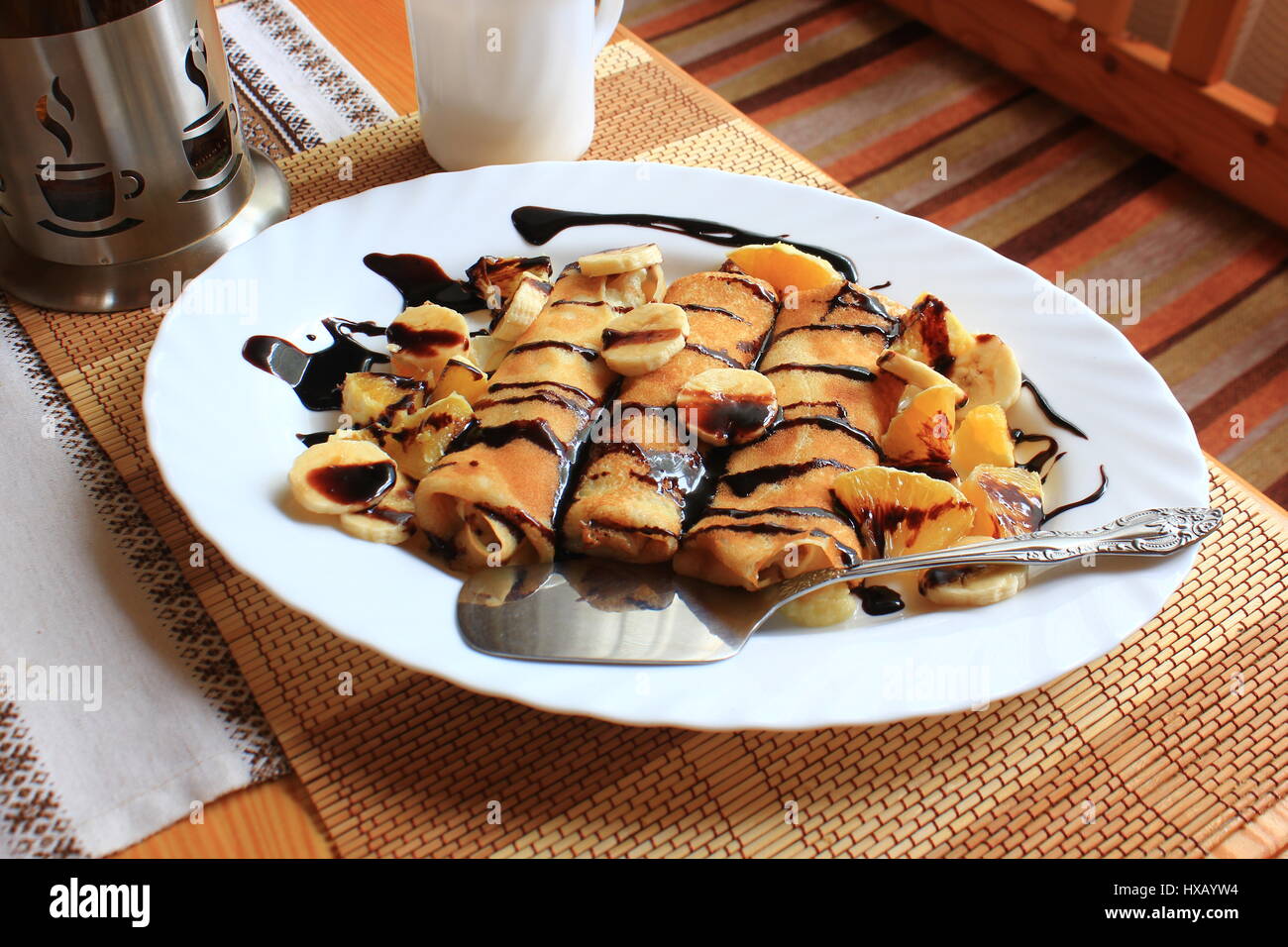 Pfannkuchen gefüllt mit Grieß, Bananen und Orangen getränkt dunklen Schokolade Stockfoto