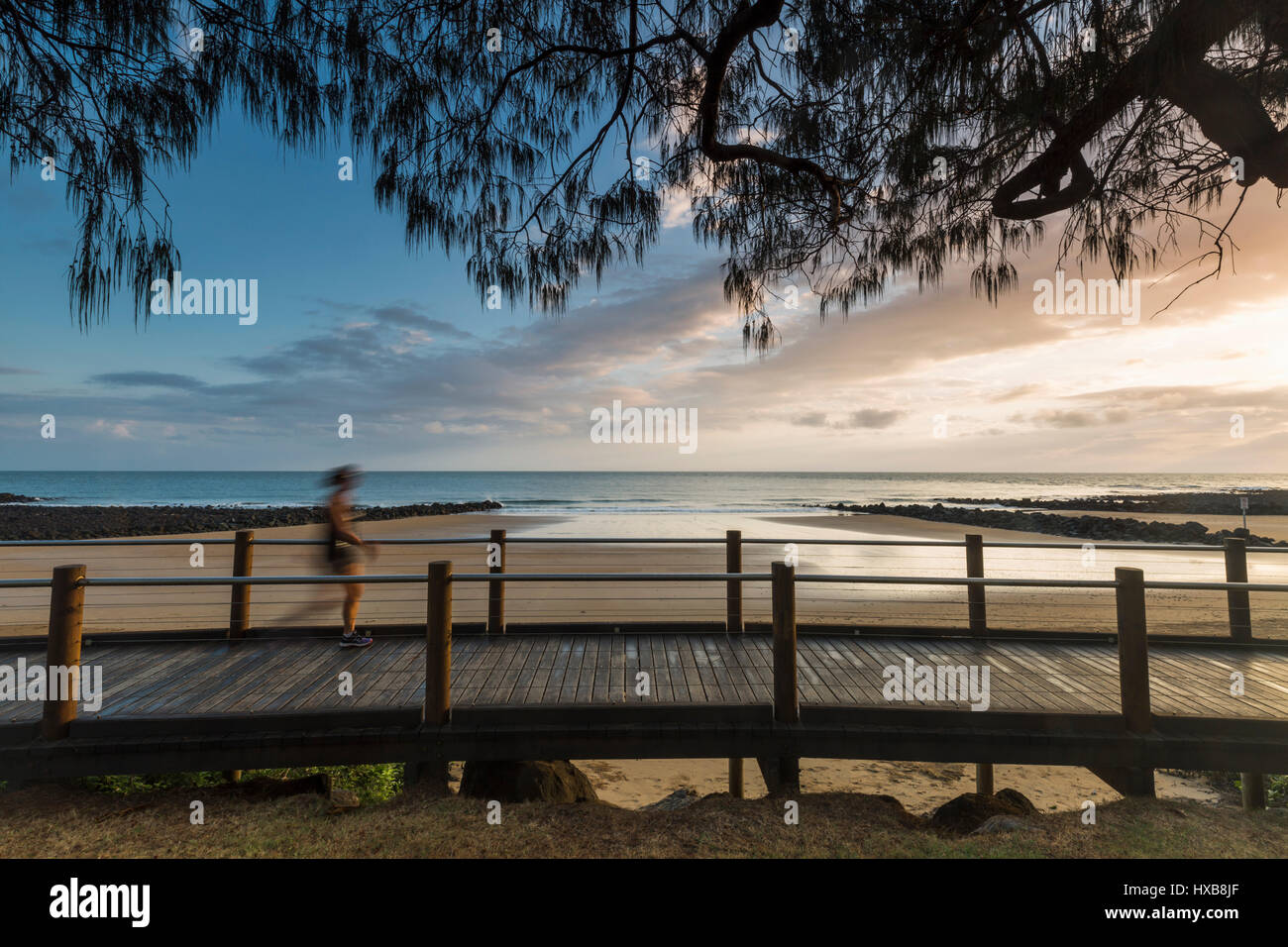 Walker auf der Esplanade Promenade bei Sonnenaufgang, Bargara Strand, Bundaberg, Queensland, Australien Stockfoto
