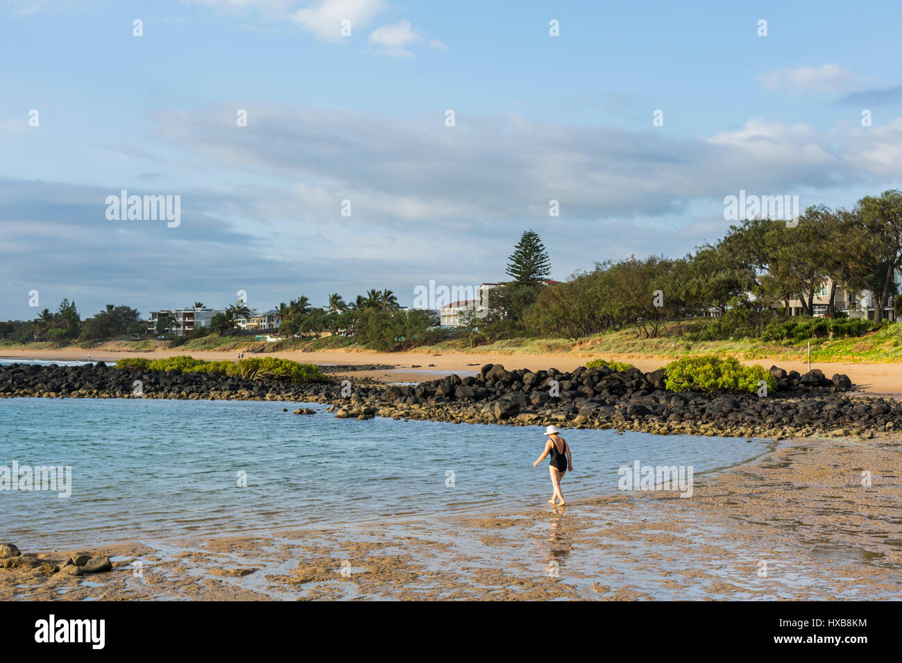 Frau zu Fuß ins Meer am Strand Bargara, Bundaberg, Queensland, Australien Stockfoto