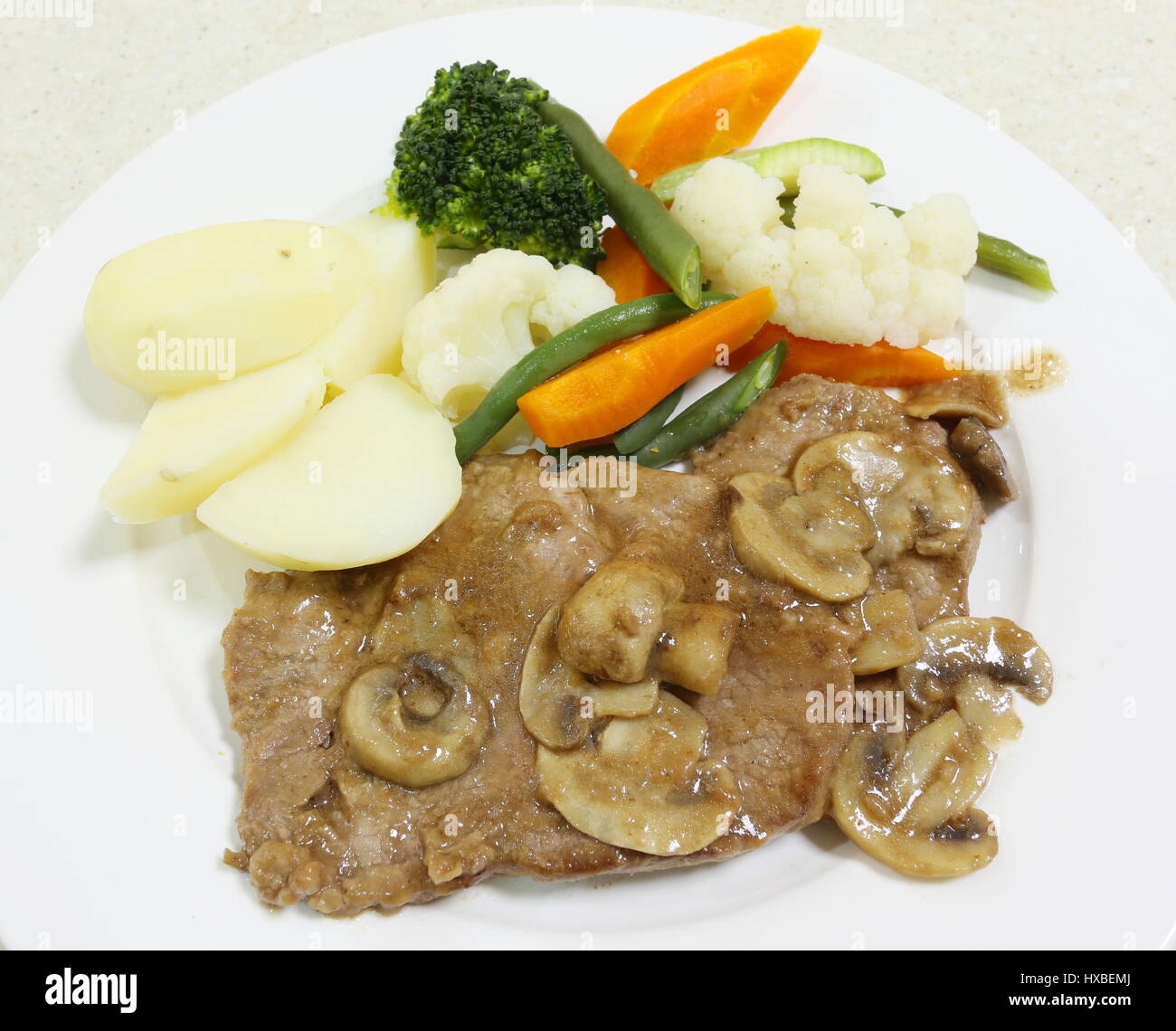 Roastbeef mit einer Pilz-Soße, Salzkartoffeln und gedünstetem Gemüse, serviert von oben Stockfoto