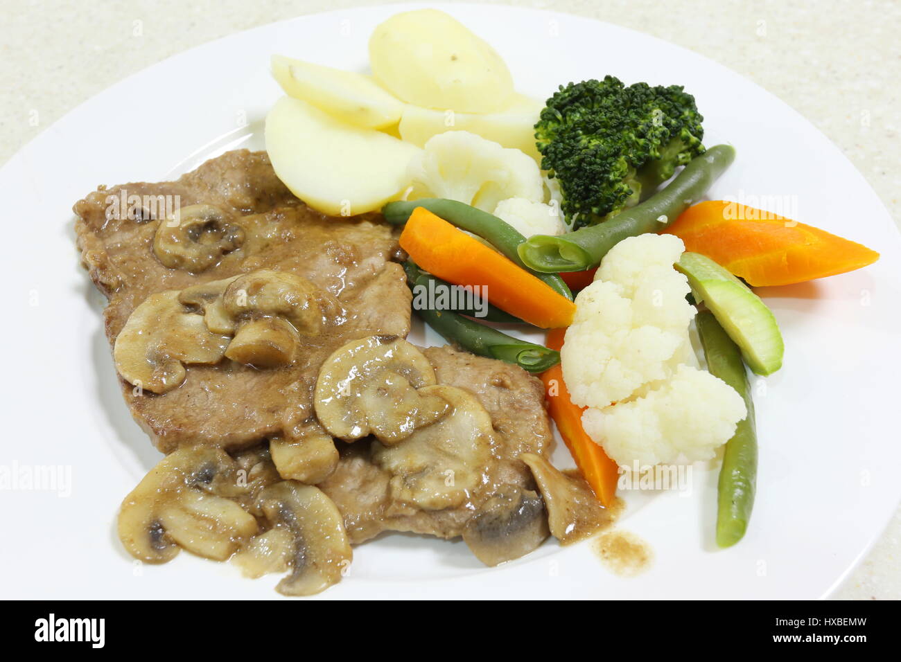 Roastbeef mit Champignon-Sauce, serviert mit Salzkartoffeln und gedünstetem Gemüse. Stockfoto