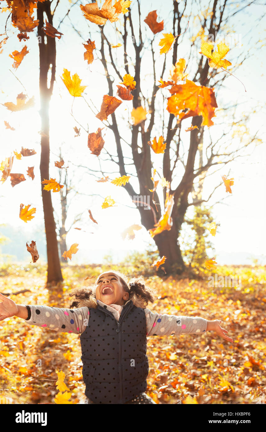 Verspielte Mädchen werfen lässt Overhead im sonnigen Herbst park Stockfoto