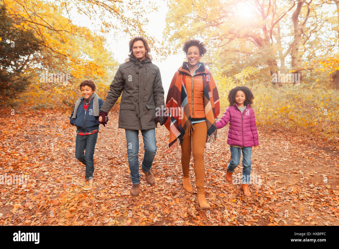 Porträt, Lächeln junge Familie Hand in Hand zu Fuß unterwegs im Herbst park Stockfoto