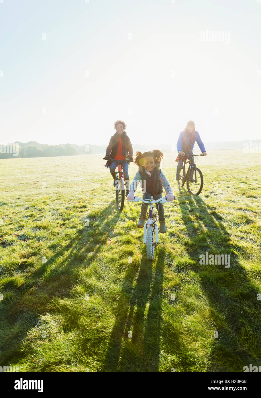 Porträt junge Familie Radfahren im sonnigen Park Rasen Stockfoto