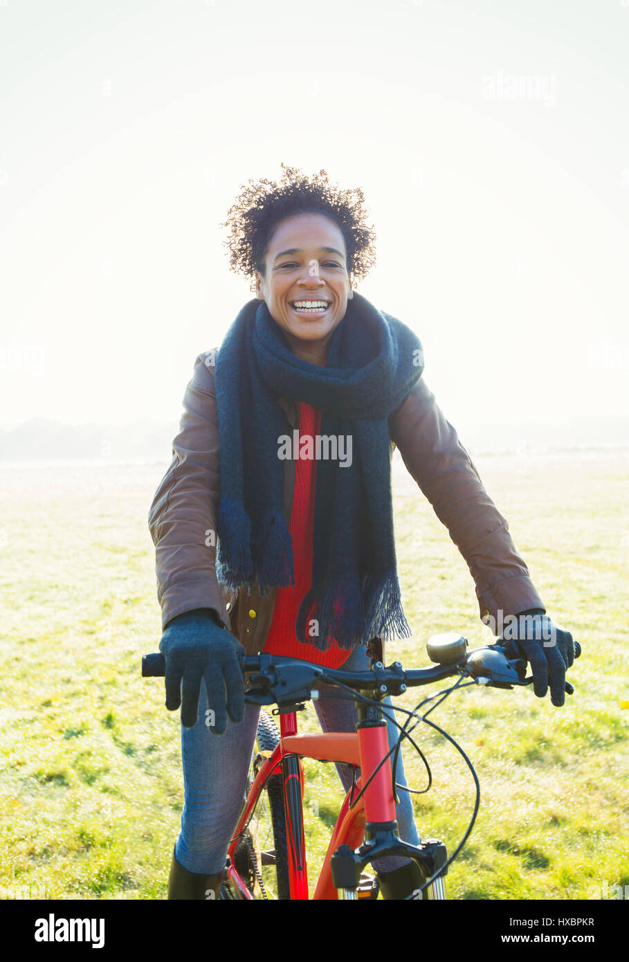 Porträt Frau Radfahren im sonnigen Park Rasen Lächeln Stockfoto