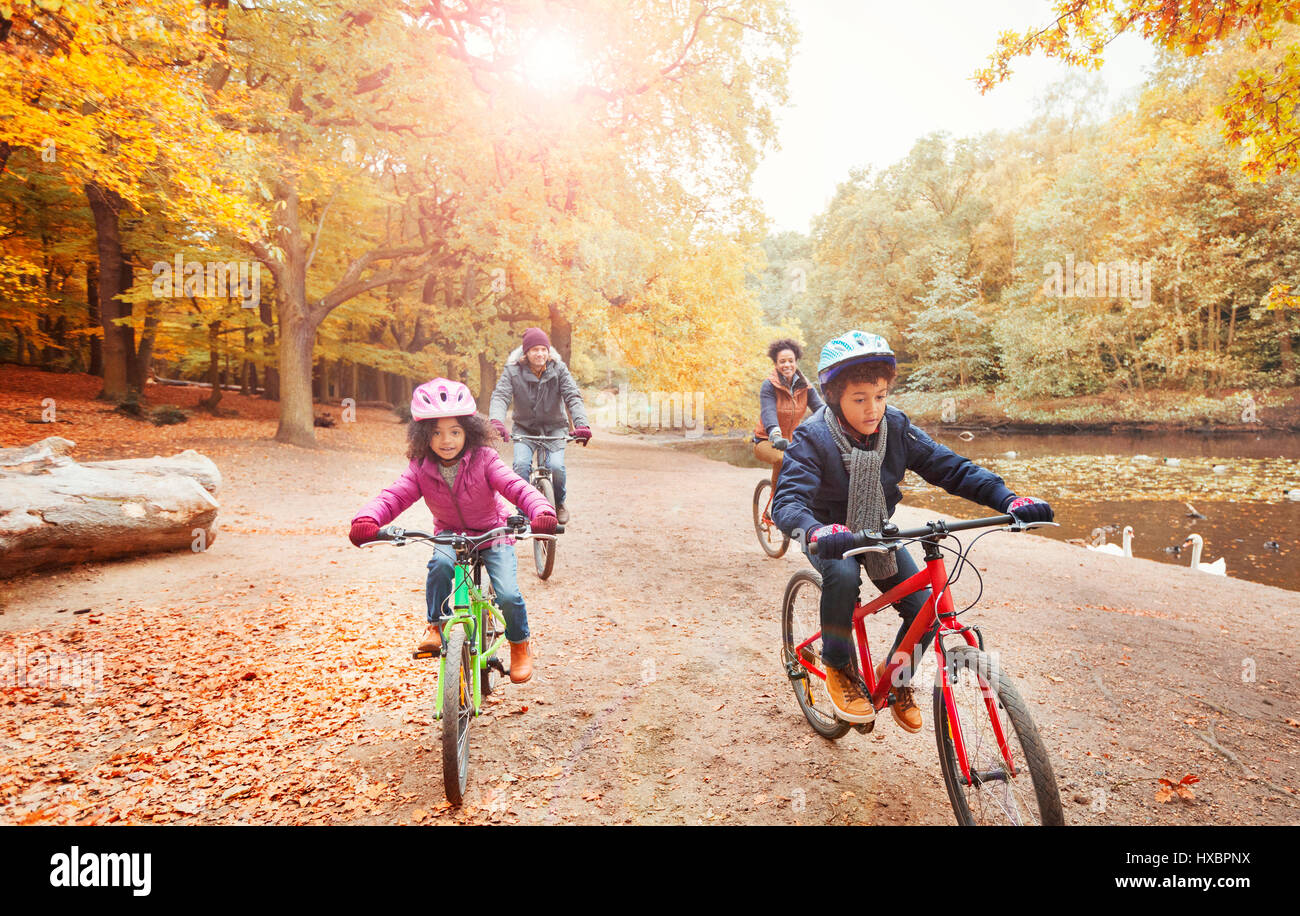 Junge Familie Radfahren entlang Teich im Herbst park Stockfoto