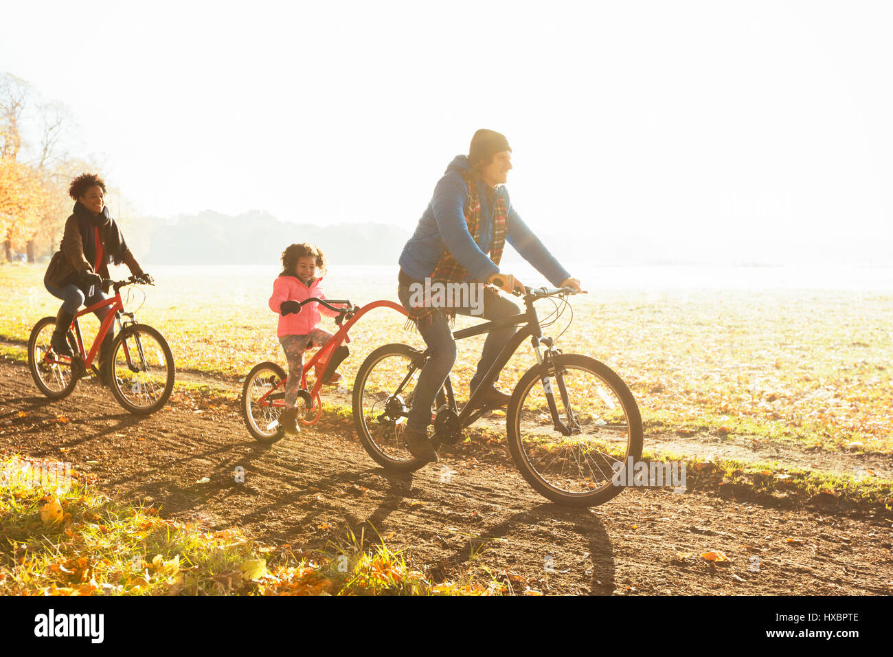 Junge Familie Radfahren auf Pfad im sonnigen Herbst park Stockfoto