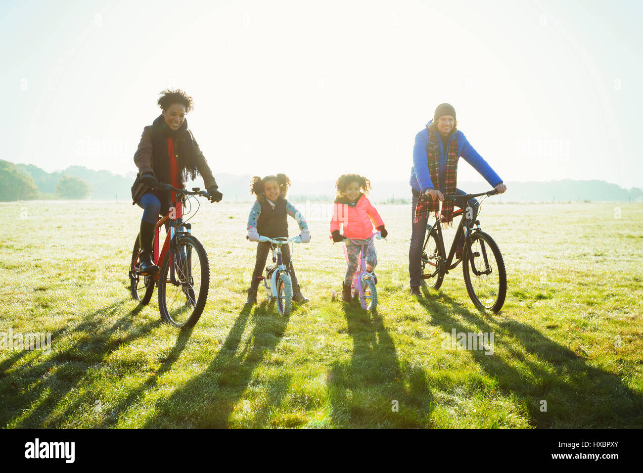 Porträt junge Familie Radfahren im sonnigen Herbst Park Rasen Stockfoto