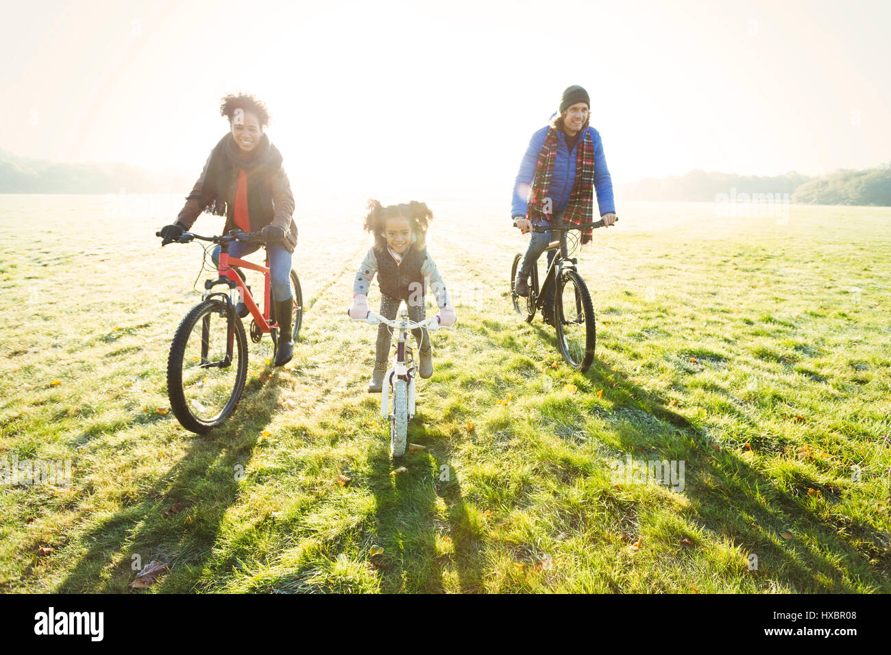 Porträt junge Familie Radfahren im sonnigen Herbst Park Rasen Stockfoto