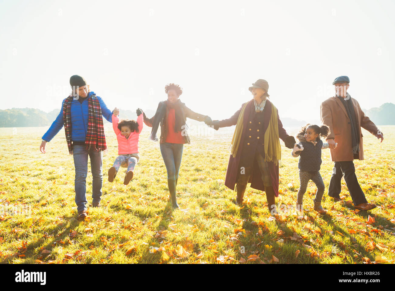 Spielerisch mehr-Generationen-Familie Wandern im sonnigen Herbst Park Rasen Stockfoto