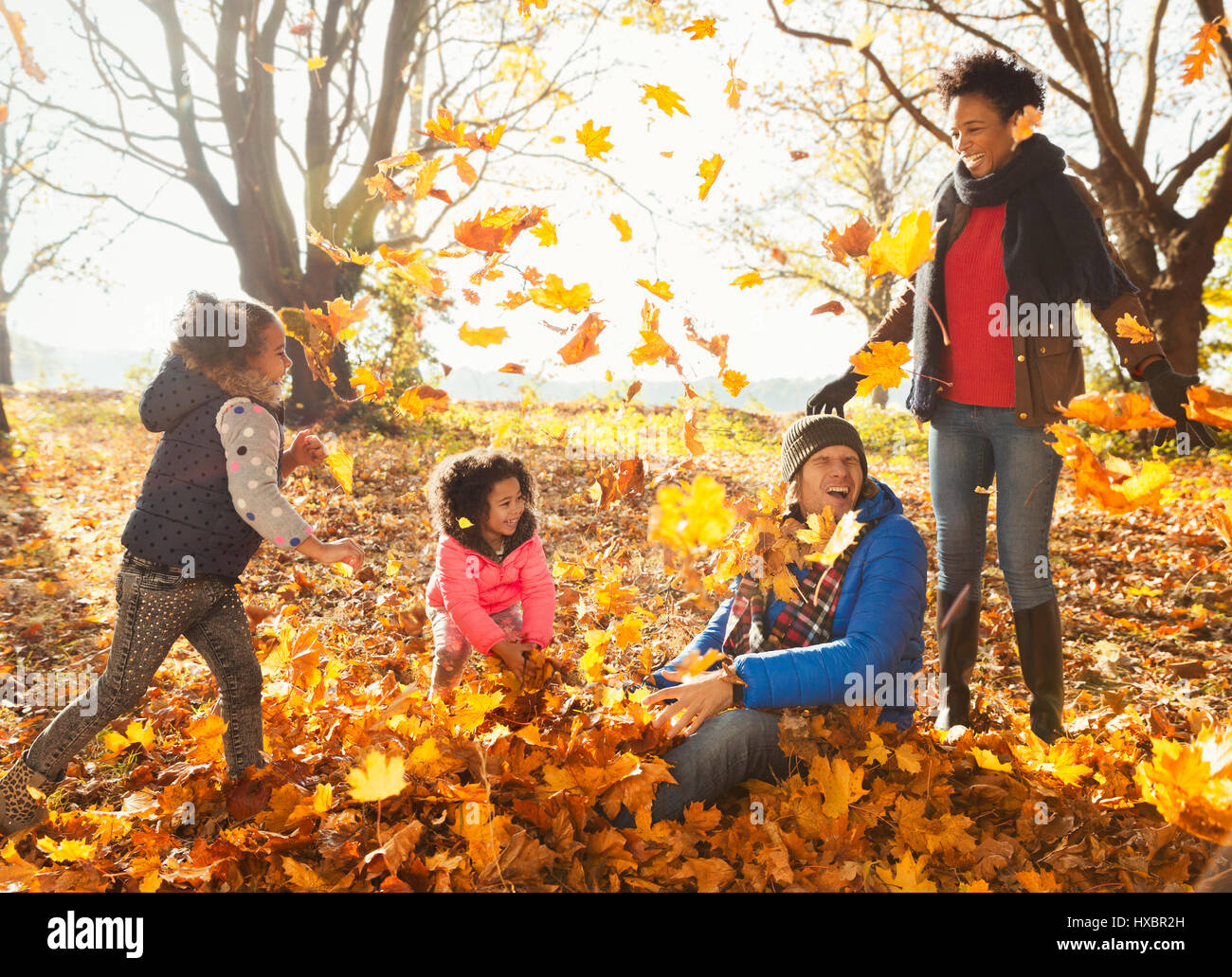 Junge Familie spielen im Herbst Blätter im sonnigen park Stockfoto