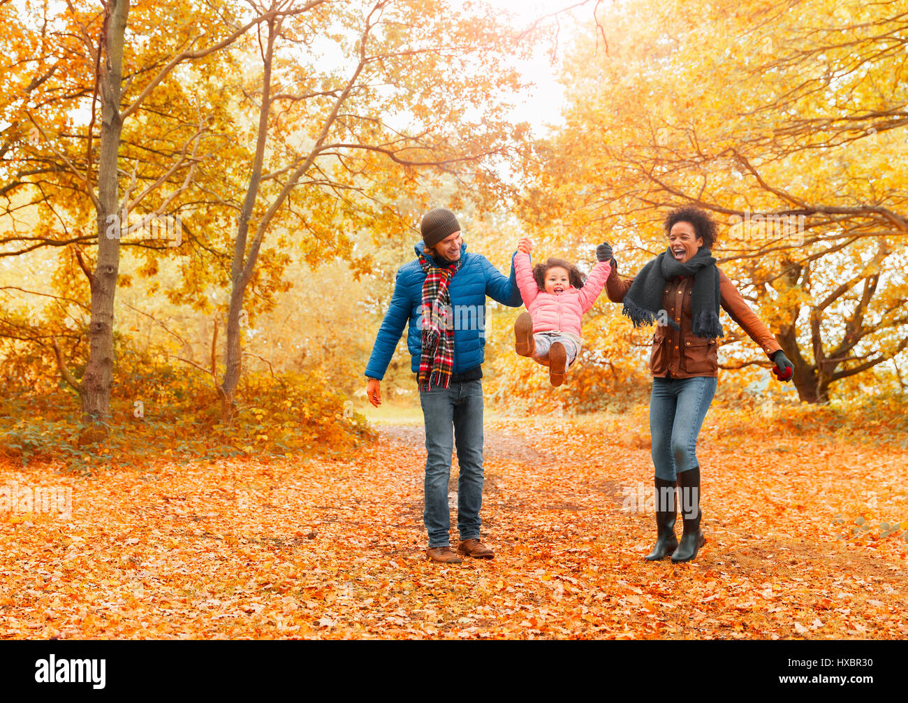 Eltern, die Tochter im Herbst Park schwingen Stockfoto