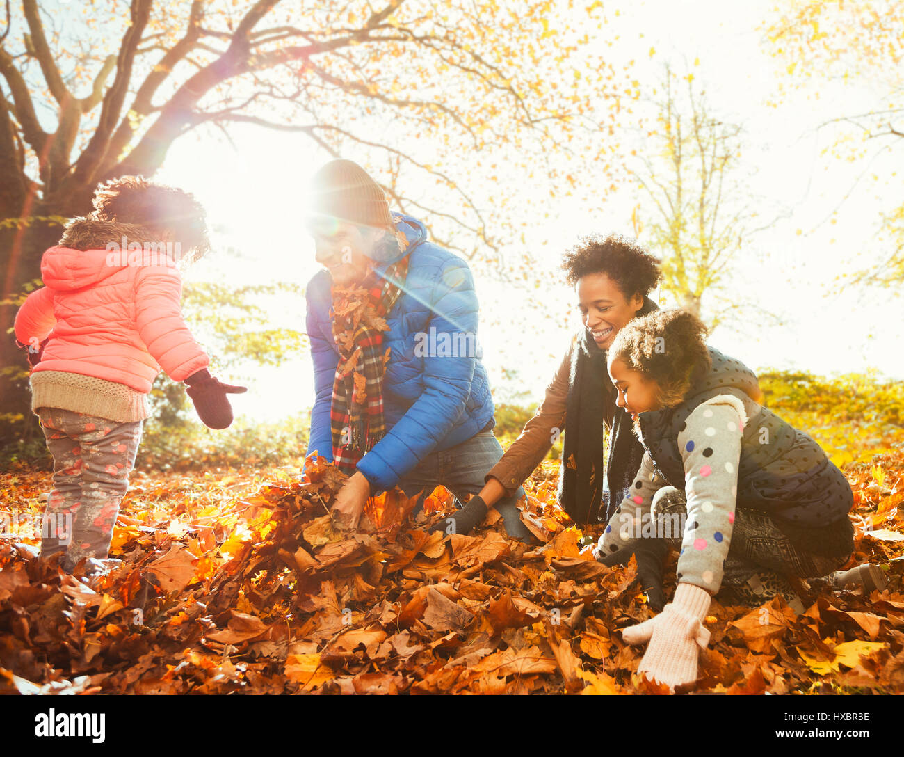 Junge Familie spielen im Herbst Blätter im sonnigen park Stockfoto