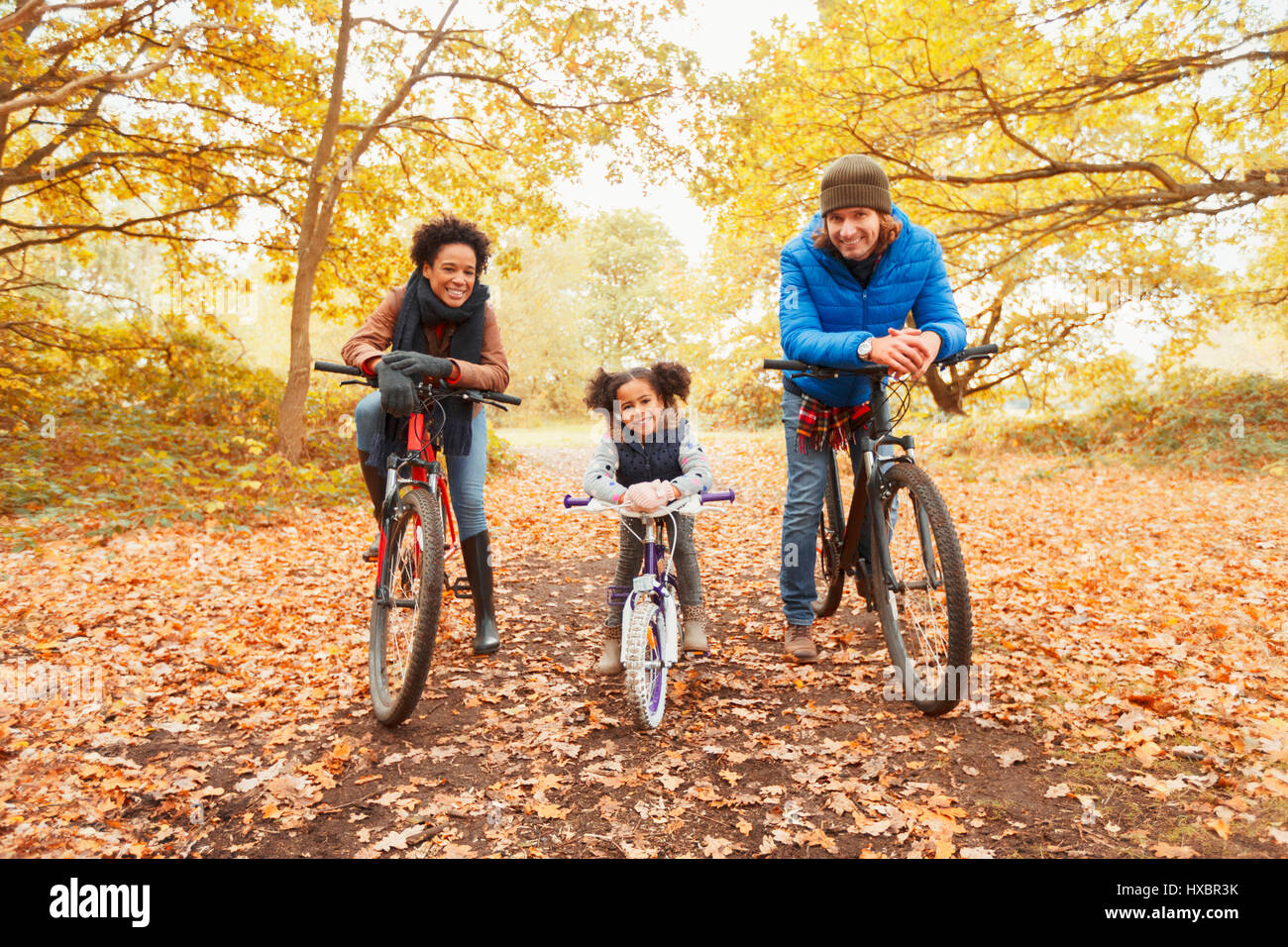 Porträt, lächelnde junge Familie Radfahren im Herbst park Stockfoto