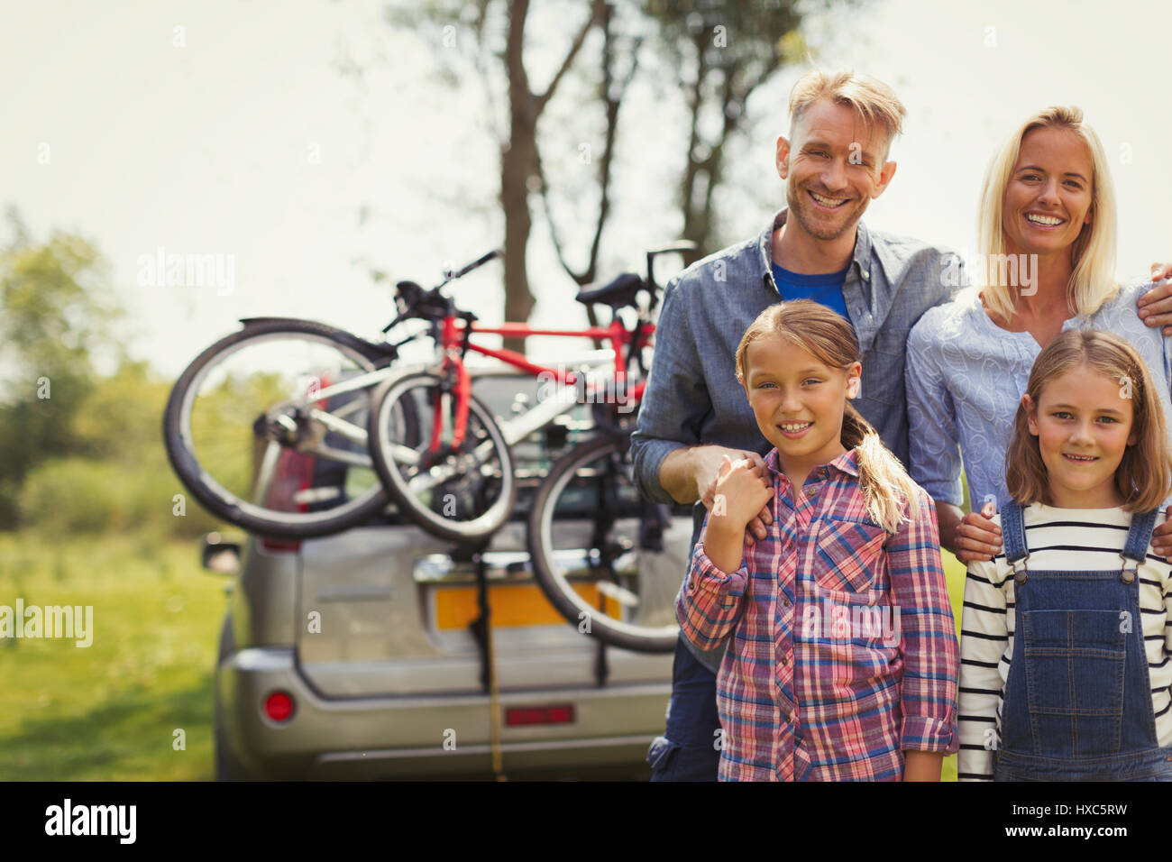 Porträt, Lächeln Familie in der Nähe von Auto mit Mountain-bikes Stockfoto