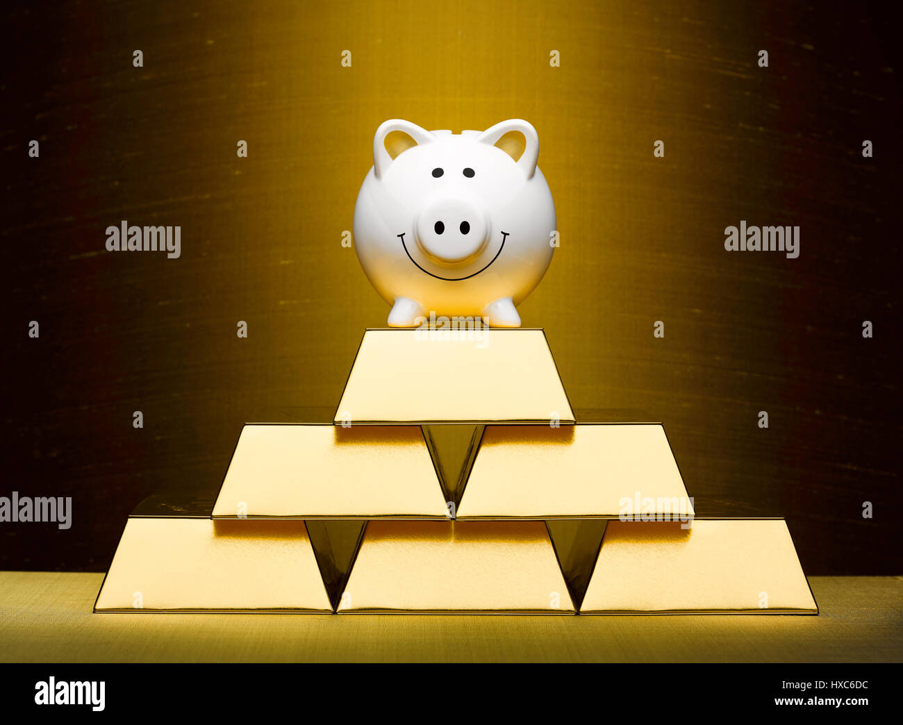 Lächelnd Sparschwein auf gestapelten Goldbarren Stockfoto