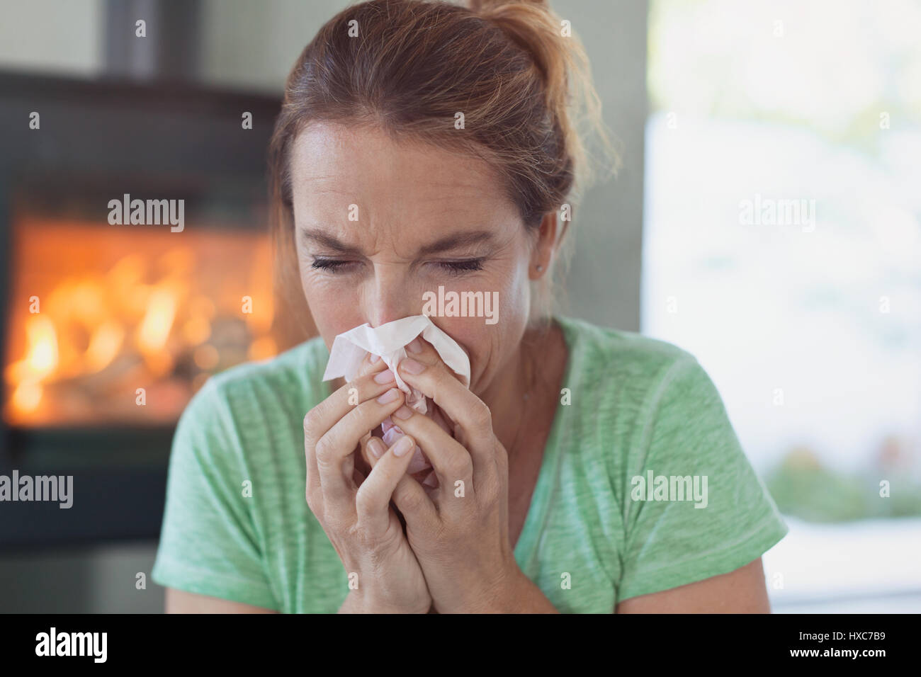 Frau mit Gewebe Nase weht Stockfoto