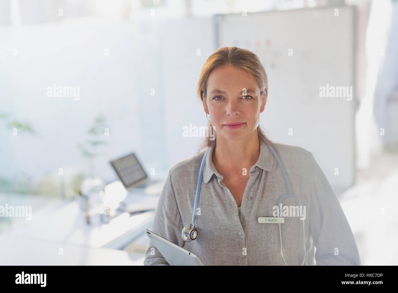 Porträt zuversichtlich Ärztin mit digital-Tablette in Arztpraxis Stockfoto