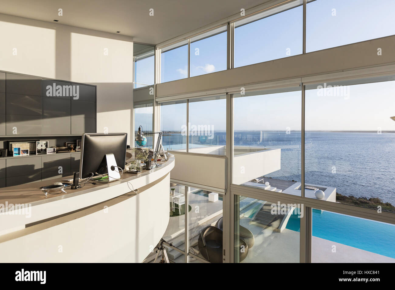 Modernen Luxus nach Hause Schaufenster Innenraum Heimbüro mit sonnigen Meerblick Stockfoto