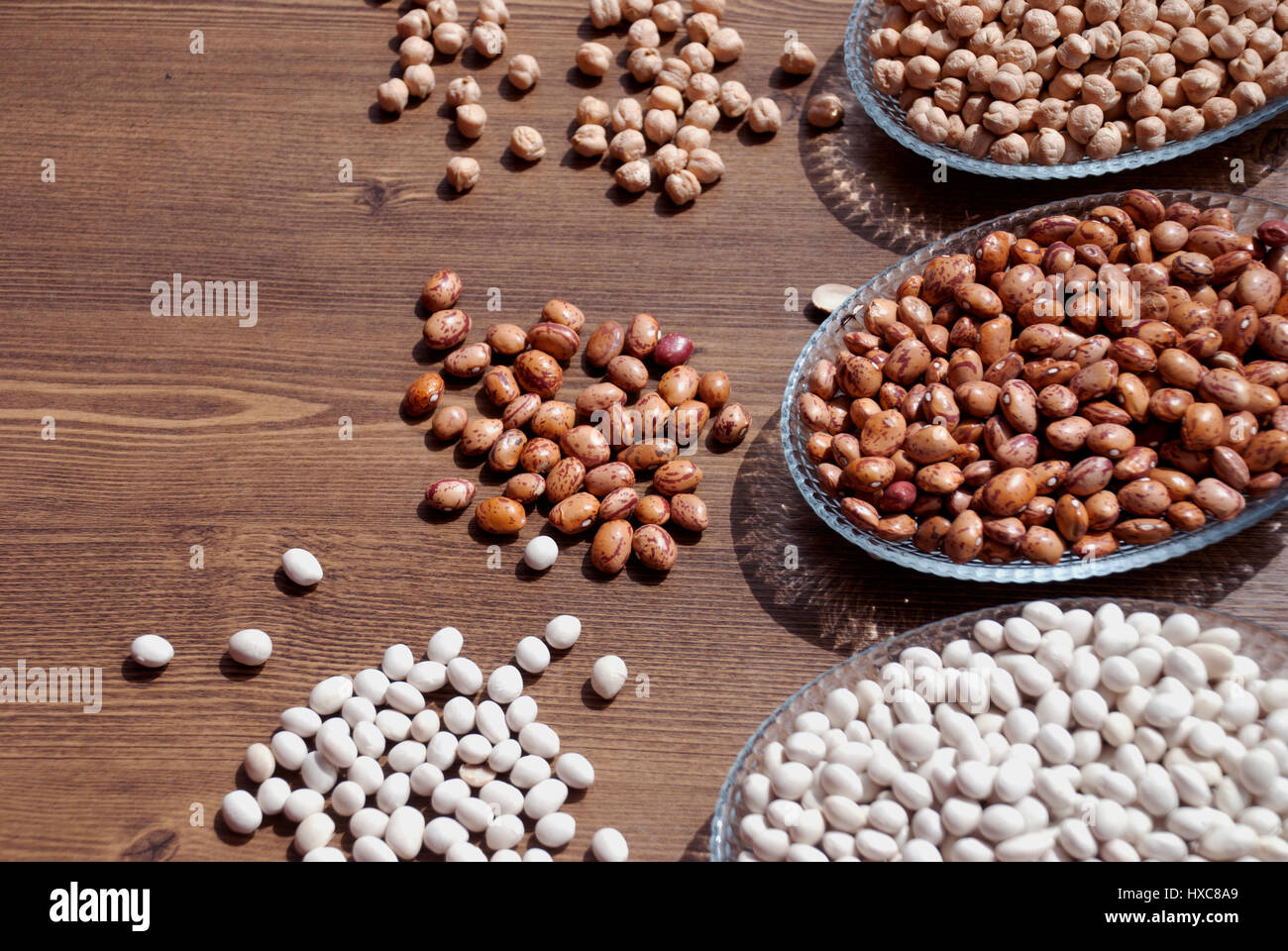 Impulse in einer Schüssel auf einem Holztisch für Bacgrounds (Gartenbohnen Bohnen, Kidney-Bohnen und Kichererbsen) Stockfoto