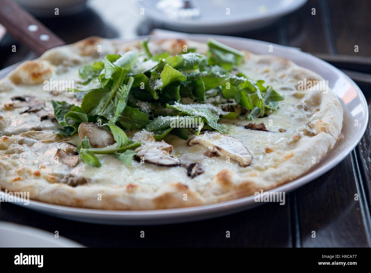 Spinat und Pilz-Pizza (Rückseite unscharf gestellt) Stockfoto