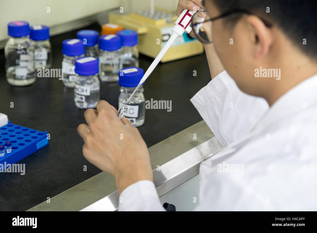 ein Forscher nutzt die Mikro Pipette in die kleine Flasche Stockfoto