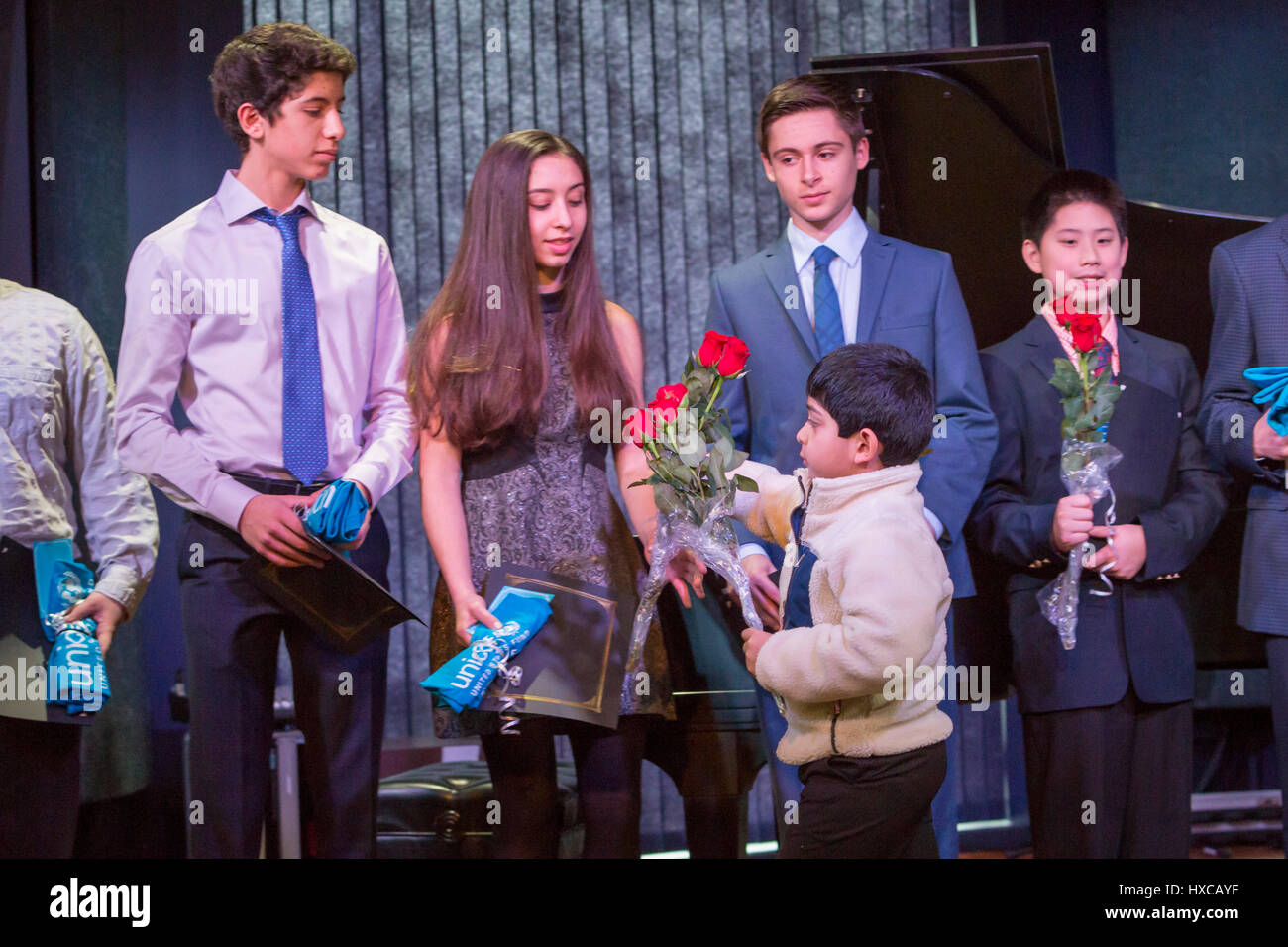 Commerce Township, Michigan - Schülerinnen und Schüler sind Rosen für die Beschaffung von Mitteln für Kinder in Kriegsgebieten in Syrien gegeben. Omar und Ziad Fehmi, deren Stockfoto