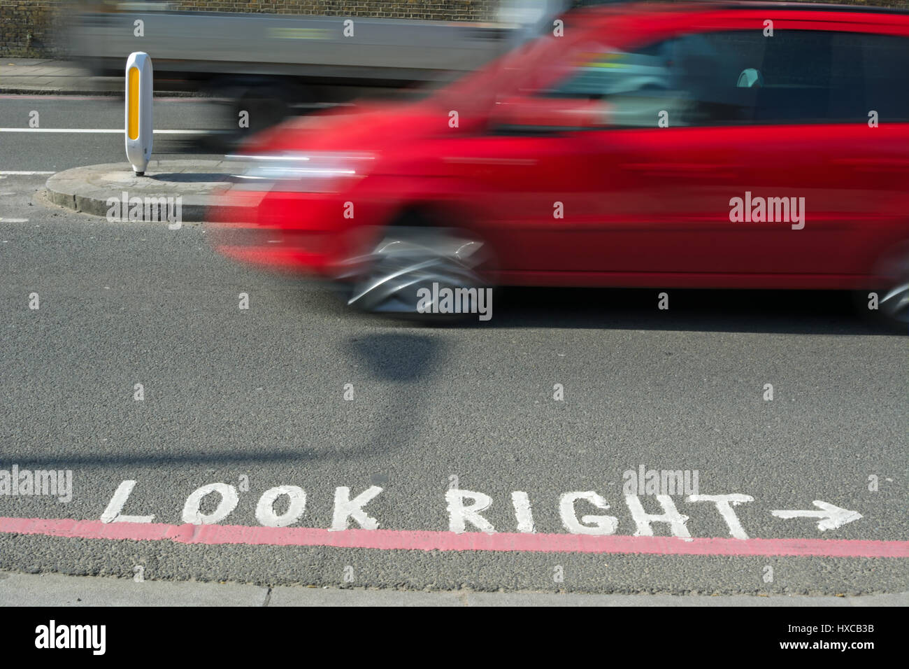 rotes Auto gesehen in Bewegungsunschärfe neben einen Blick rechts Straßenmarkierung Stockfoto