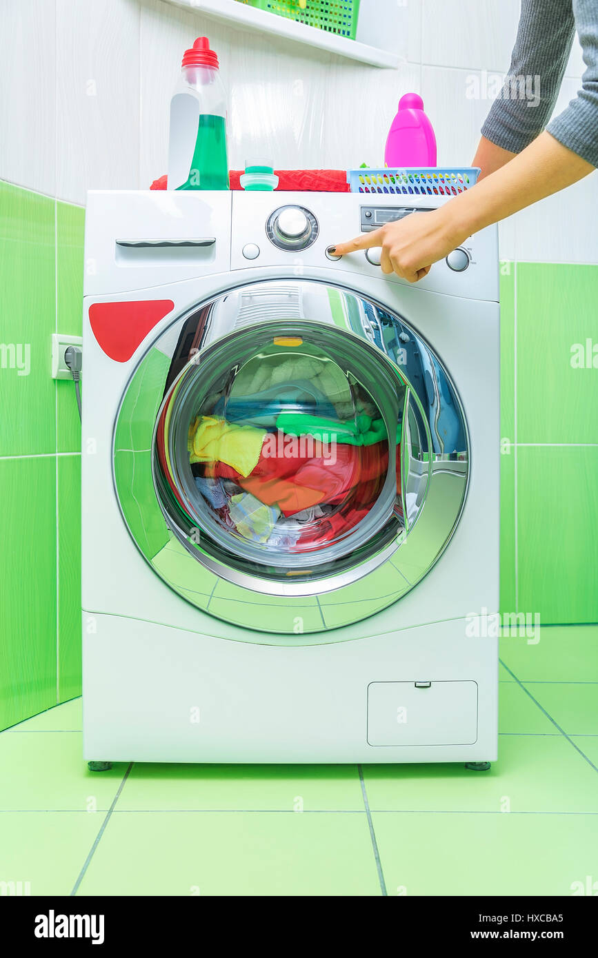 Die Hand Einer Frau Drückt Einen Knopf Auf Der Waschmaschine. Starten Sie  Den Waschgang Stockfotografie - Alamy