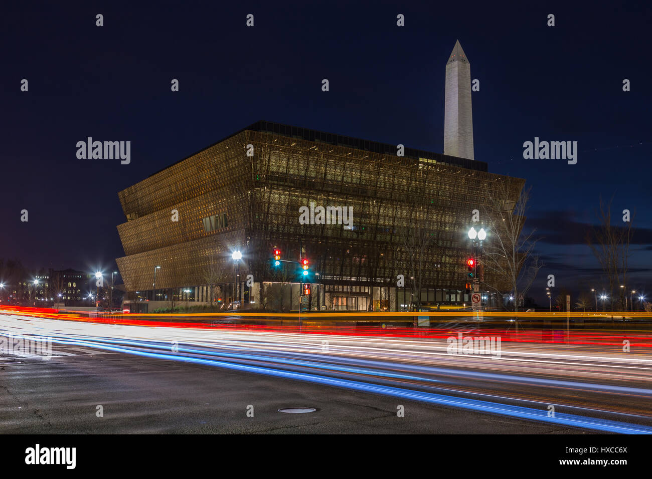 Verkehr schafft Lichtspuren in der Dämmerung außerhalb des Smithsonian National Museum of African American History und Kultur (NMAAHC) in Washington, DC. Stockfoto