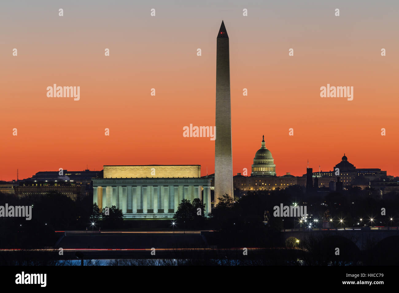 Das Lincoln Memorial, Washington Monument und US Capitol Gebäude gesetzt gegen einen orangefarbenen Himmel während der Morgendämmerung in Washington, DC. Stockfoto