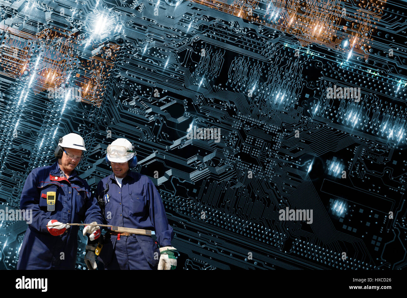 zwei hallo Tech-Techniker mit einem futuristischen große Computer-Motherboard im Hintergrund Stockfoto