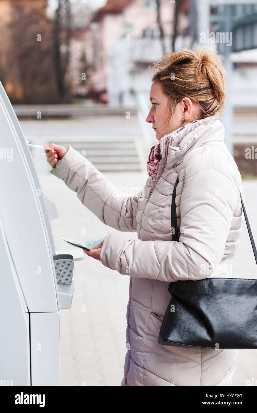 Frau herausziehen Geld von Geldautomaten Stockfoto