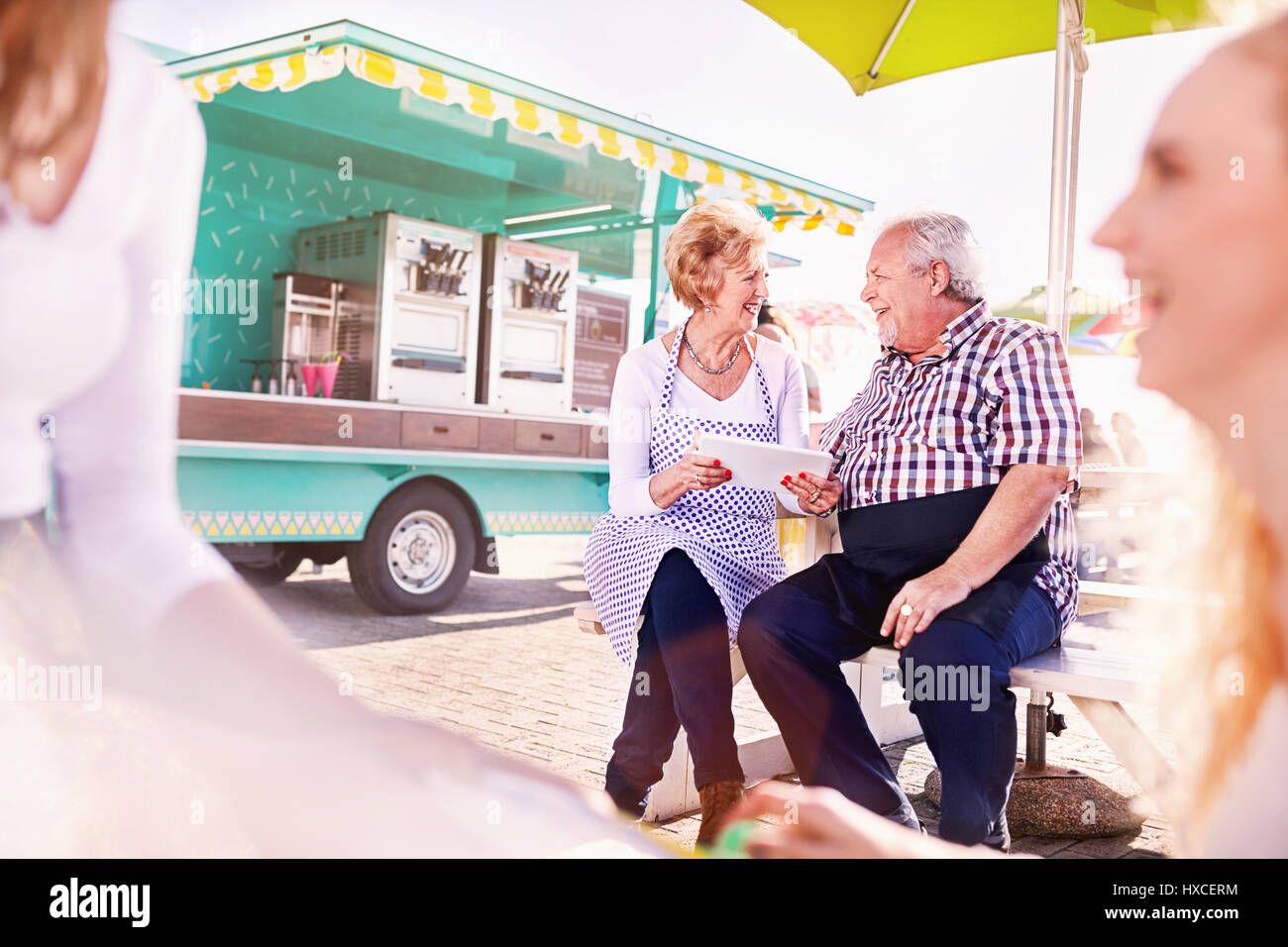 Lächelnd Senior Business Inhaber mit digitalen Tablet außerhalb essen Warenkorb Stockfoto