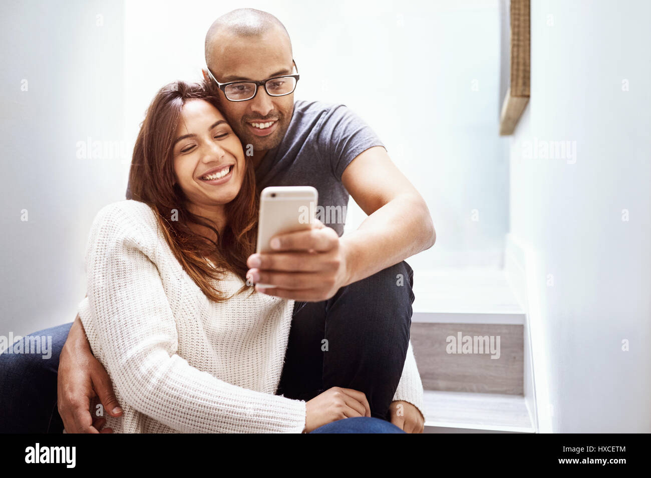 Lächelndes Paar mit Kamera Handy unter selfie auf Treppen Stockfoto