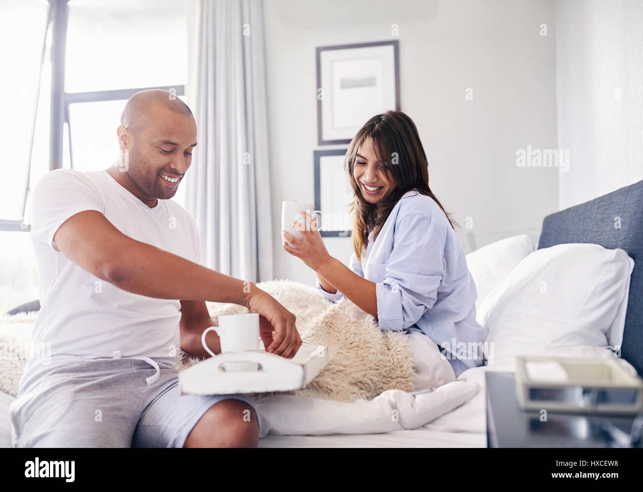 Lächelndes Paar trinken Kaffee im Bett Stockfoto