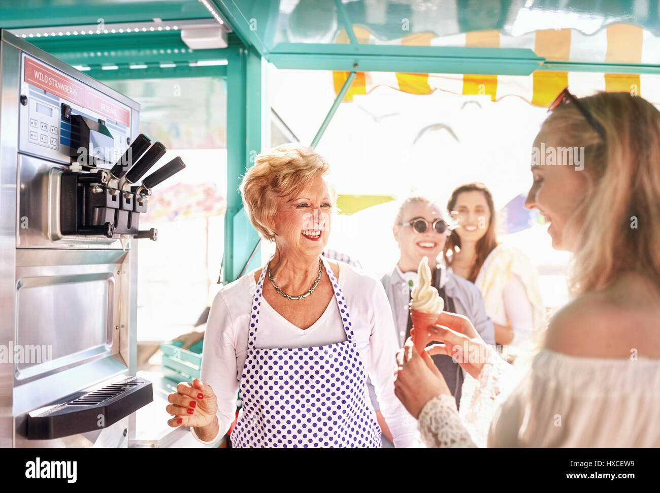 Lächelnd älterer weiblicher Unternehmer mit Eis zu junge Frau an Nahrungsmittel Warenkorb Stockfoto