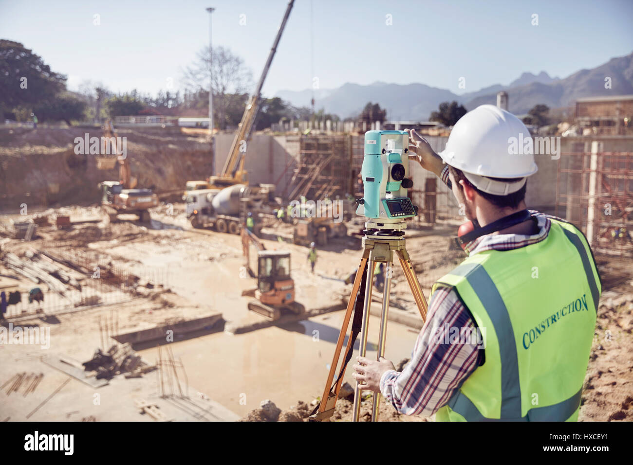 Bauarbeiter Surveyor mit Theodoliten bei Sunny Baustelle Stockfoto