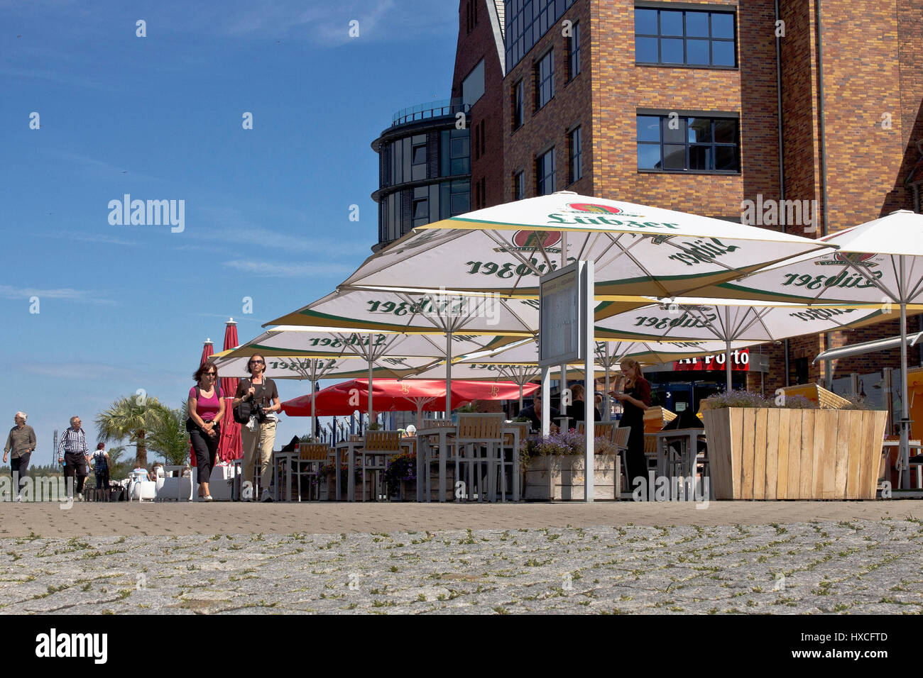 Terrassen von Restaurants und Cafés vor der renovierten Speicher-Gebäude im Stadthafen Rostock, Outdoor-Terrassen der Restaurants und café Stockfoto