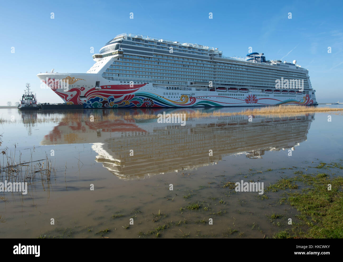 Oldersum, Deutschland. 27. März 2017. Das neueste Kreuzfahrtschiff der Meyer Shipyard in Papenburg, 'Norwegische Freude', kommt an der Nordsee während seiner Übertragung Tordurchgang Fluss Ems in Oldersum, Deutschland, 27. März 2017. Der Riese für den chinesischen Markt gebaut, wird es die nächste Flut warten. Das 324 Meter lang und 167.800 BRZ großen Passagier Schiff der US-Reederei, die Norwegian Kreuzfahrten im niederländischen Eemshaven andocken und dann wird es für die Nordsee verlassen. Foto: Ingo Wagner/Dpa/Alamy Live News Stockfoto