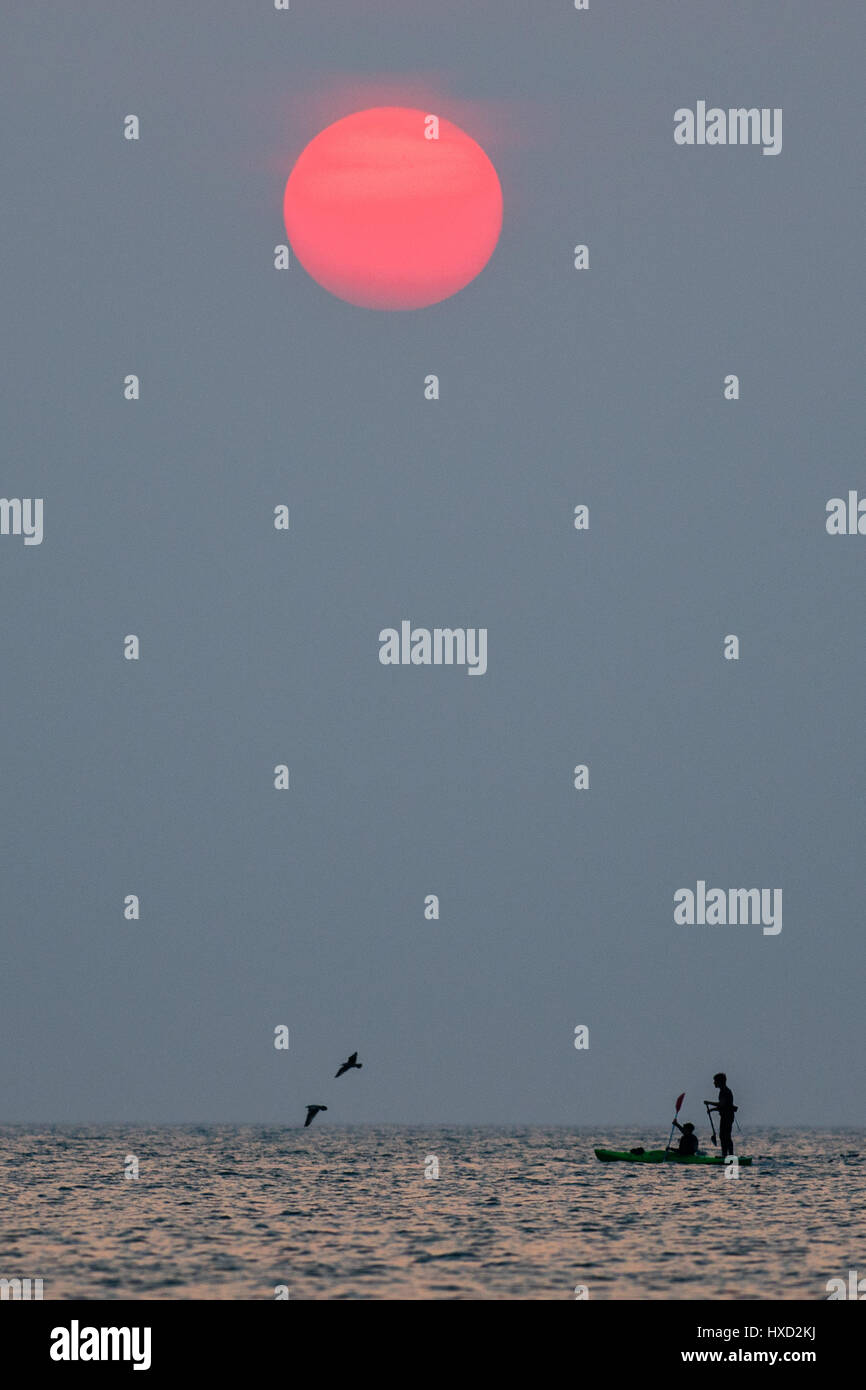 Aberystwyth, Wales, UK. 27. März 2017. UK-Wetter: Menschen paddle-Boarding und Kajakfahren auf das flache Meer bei Sonnenuntergang an der Cardigan Bay, Wales, am letzten Abend warme Schönwetterperiode bevor unruhige und feuchtere Bedingungen in den nächsten Tagen im Rollen Bildnachweis: Keith Morris/Alamy Live News Stockfoto