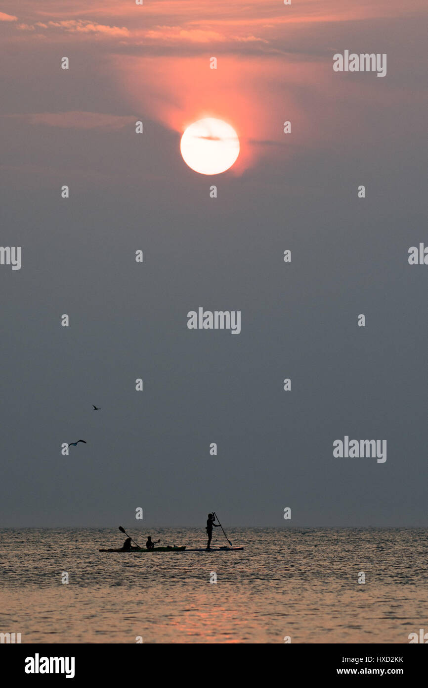 Aberystwyth, Wales, UK. 27. März 2017. UK-Wetter: Menschen paddle-Boarding und Kajakfahren auf das flache Meer bei Sonnenuntergang an der Cardigan Bay, Wales, am letzten Abend warme Schönwetterperiode bevor unruhige und feuchtere Bedingungen in den nächsten Tagen im Rollen Bildnachweis: Keith Morris/Alamy Live News Stockfoto